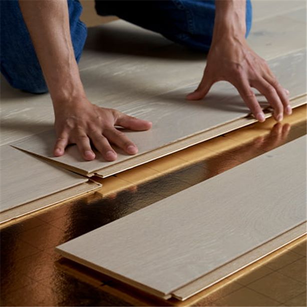 man installing a pergo parquet floor on an underlay
